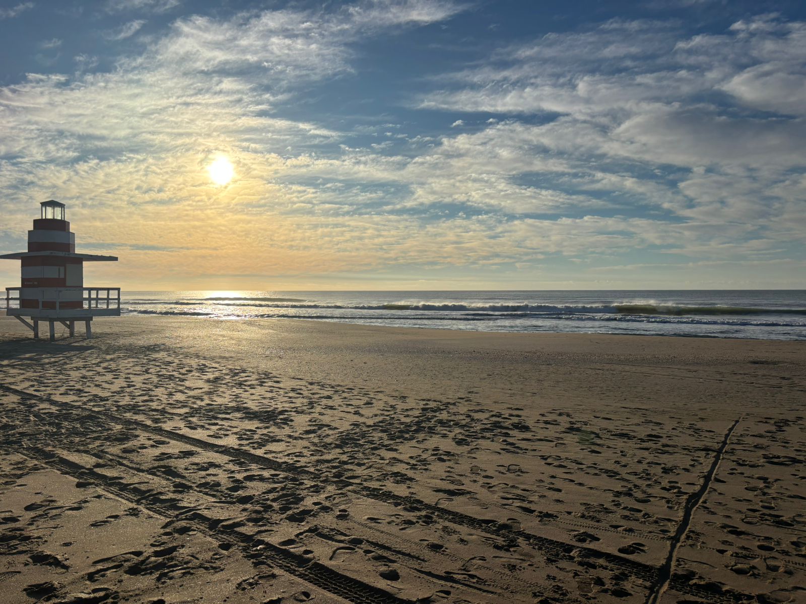 Faro y playa de Pinamar al atardecer con cielo dorado