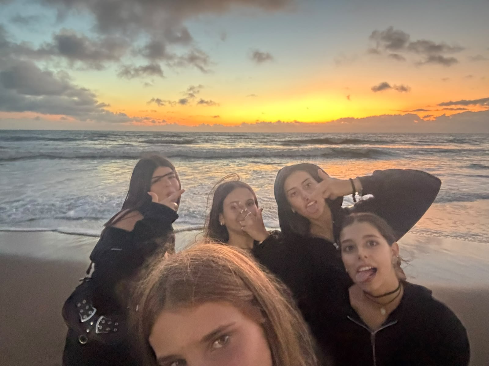 Grupo de amigas tomándose una selfie en la playa de Pinamar al atardecer